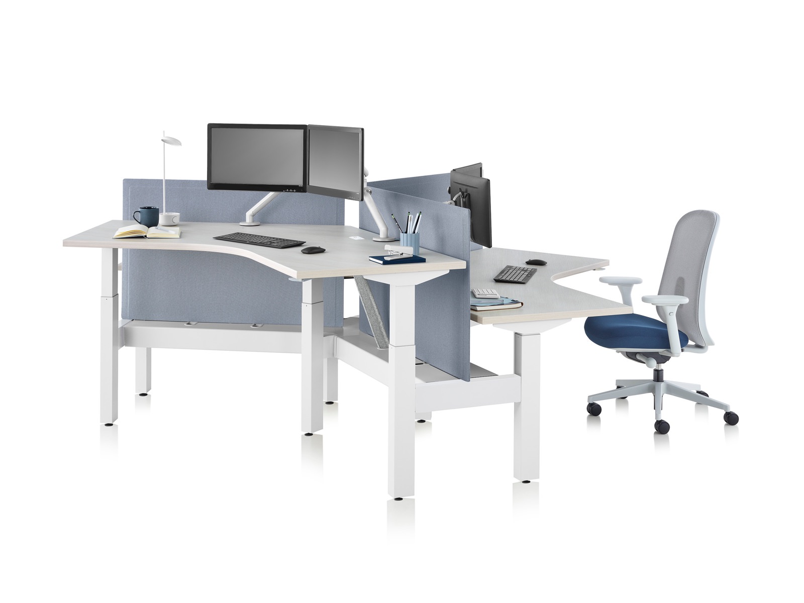 Standing desk system, Nevi Link, with 120-degree work surfaces, Lino Chairs, and screens. One of the three desks is raised at a standing height.