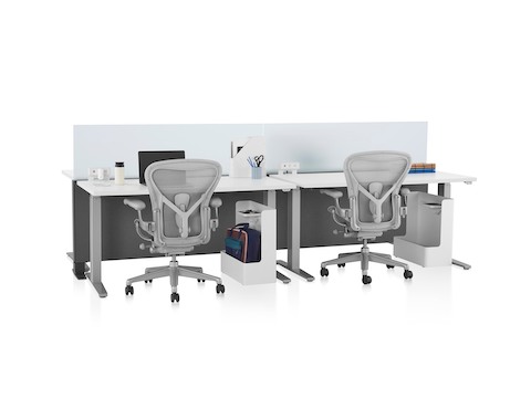 Gray Canvas Channel with glass screens, white Motia Sit-to-Stand Tables, lower bag storage, and light gray Aeron Chairs