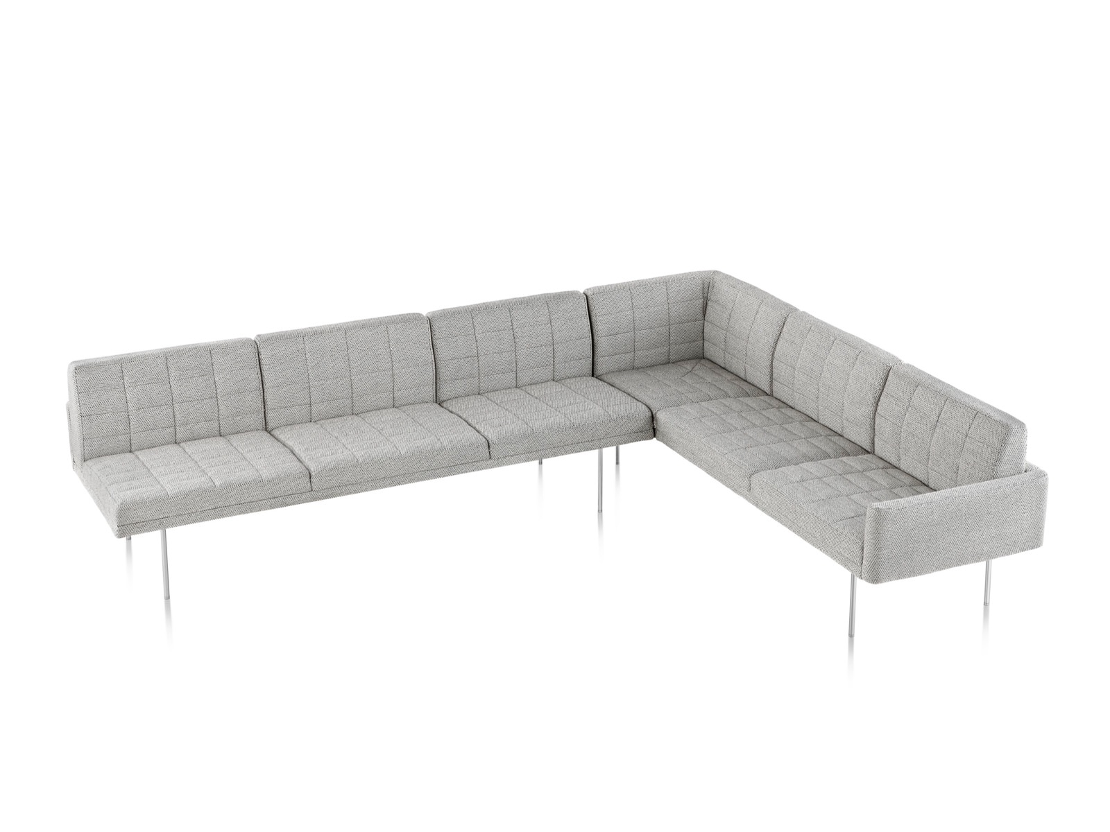 Overhead view of a Tuxedo sectional with quilted light gray upholstery.