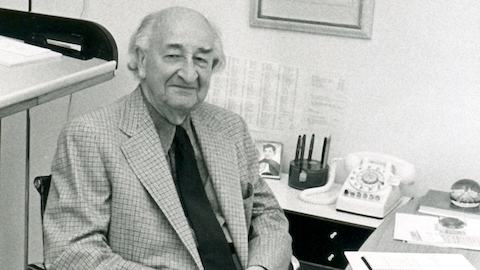 A portrait of D.J. De Pree sitting at a desk in an Eames Aluminum Group Chair.