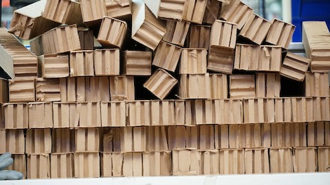 Corrugated cardboard packaging materials are arranged in a stack.