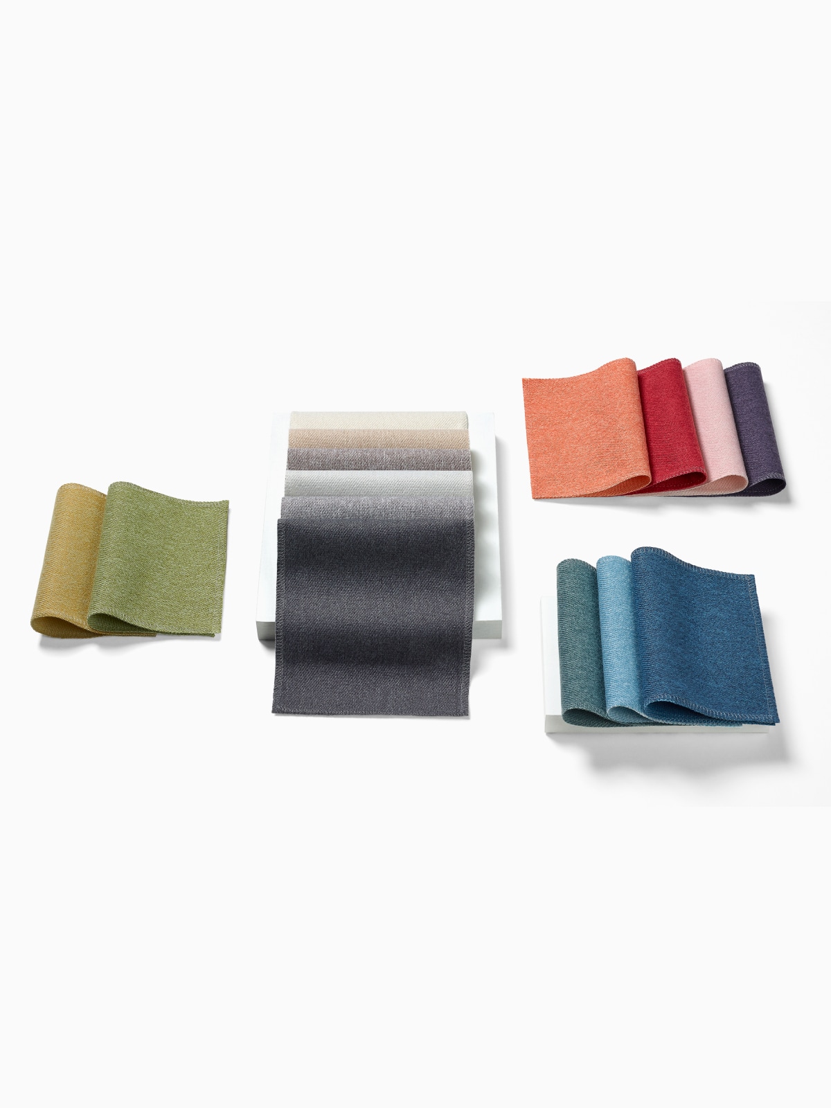 A top view of multiple, folded colorful Whisper fabrics.