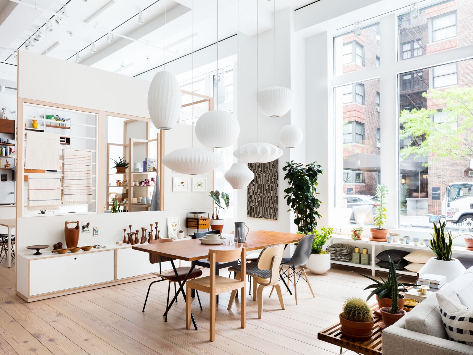 Environmental shot of Nelson X-Leg Table with assorted Herman Miller and DWRC dining chairs and Nelson Bubble Pendant Lamps over table.