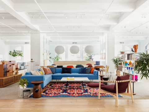 Environmental shot of blue Bolster Sofa, white Eames Coffee Table, and burgundy Crosshatch Side Chair with light brown frame.