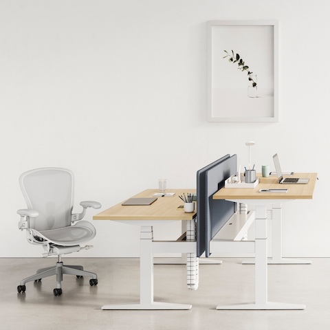 Deux bureaux sit-to-stand Ratio placés à des hauteurs différentes et associés à des chaises de bureau Aeron noires.
