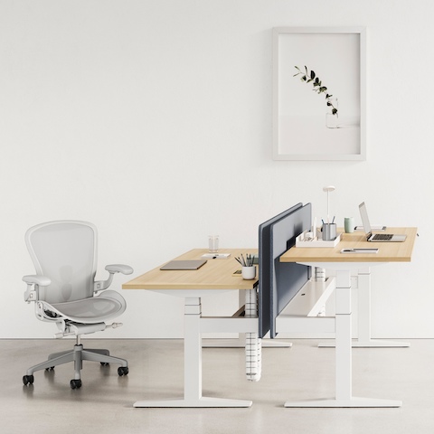Two Ratio sit-to-stand desks positioned at different heights and paired with an Aeron office chair. Two Ratio sit-to-stand desks positioned at different heights and paired with an Aeron office chair.