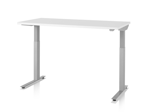 A Nevi standing desk with light gray legs and white work surface raised to standing height. A Nevi standing desk with light gray legs and white work surface raised to standing height.