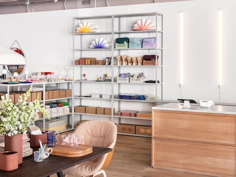A brightly lit HAY retail space at the Fulton Market Showroom, featuring housewares and accessories on shelves and tabletops. 