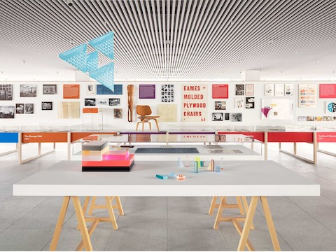 An exhibit space at the Fulton Market Showroom with colorful displays and a white wall with various posters and photos. 