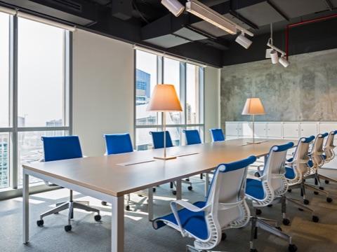 A conference setting in the Dubai showroom featuring ten Setu Chairs in blue fabric surrounding a conference table.