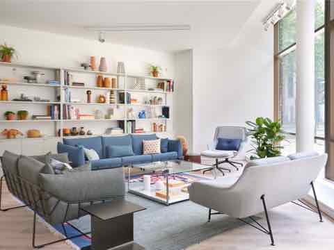 Collection of sofas, a lounge chair and side tables in front of a large bookcase.