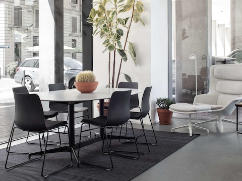 Een Civic tafel met een licht marmeren blad en zwarte Polly-stoelen.