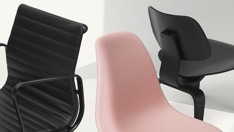 Um couro preto Eames Alumínio Copada de grupo, uma cadeira Eames Shellies cor-de-rosa e uma cadeira preta de contraplacado moldado Eames agrupadas.