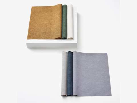 Two stacks of 100% recycled content fabric swatches in textured, neutral colors.