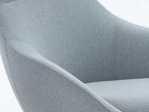 Detail van een stoel met lichtblauwe geweven stof.