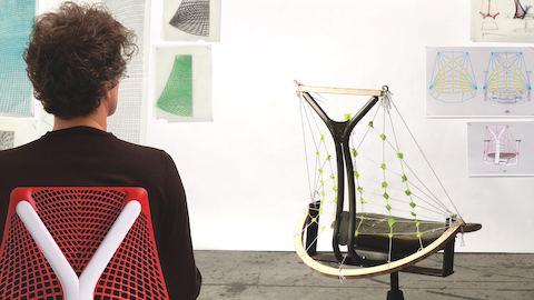 Designer Yves Béhar examine un modèle de la chaise de bureau Sayl.