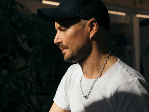 A headshot of designer Stefan Diez of Diez Office standing at a table.