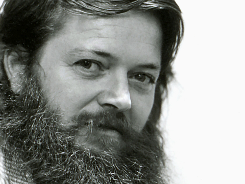 A black and white headshot of designer Ray Wilkes. Viewed at a three-quarter front angle.