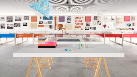 An exhibit space at the Fulton Market Showroom with colorful displays and a white wall with various posters and photos.