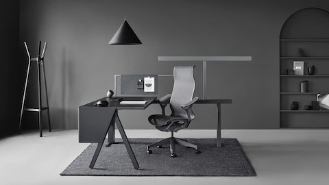 A Canvas Vista workstation in black and gray with a dark gray Cosm office chair. Select to go to the Canvas Vista product page.