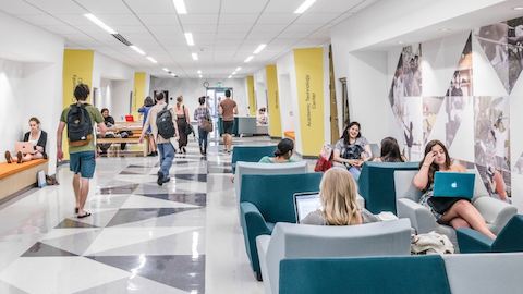 A well-lit hallway with students studying in Swoop Lounge Furniture. Select to find out how we help college and university leaders create learning spaces that can keep pace with students.