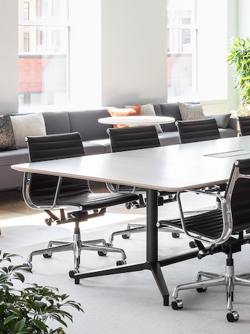 A large well-lit conference room with a Headway Table and black Eames Aluminum Group chairs.