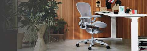 A home office environment, with a Motia table with height adjustment and an Aeron Mineral chair