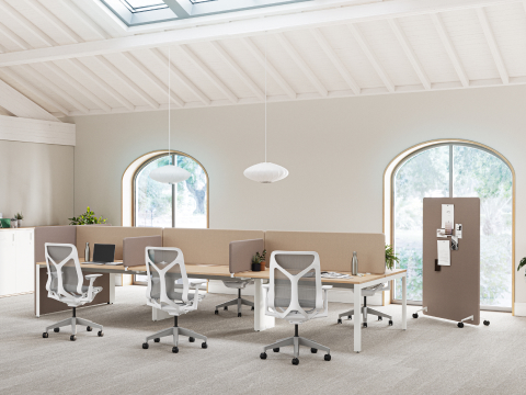 Een helder verlichte kantoorruimte met Layout Studio-werkstations met bruine Bound-schermen, Cosm-stoelen en een bruin mobiel Bound-scherm op de achtergrond.