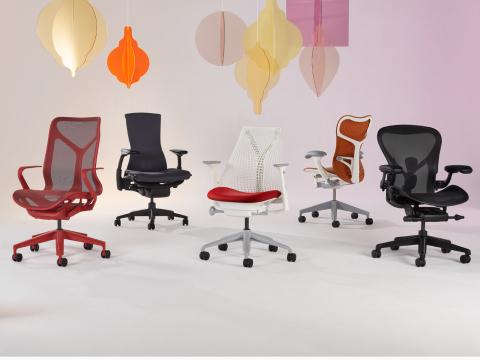 A Sayl chair, Mirra 2 chair, and an Aeron chair on a faded background with hanging ornaments in a variety of colors.