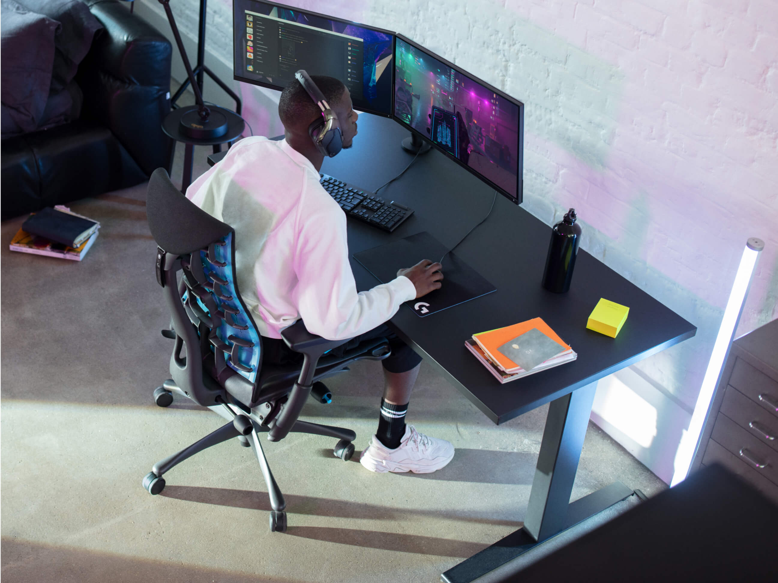 Gamer sits immersed at his all-black ergonomic setup in an Embody Gaming Chair.