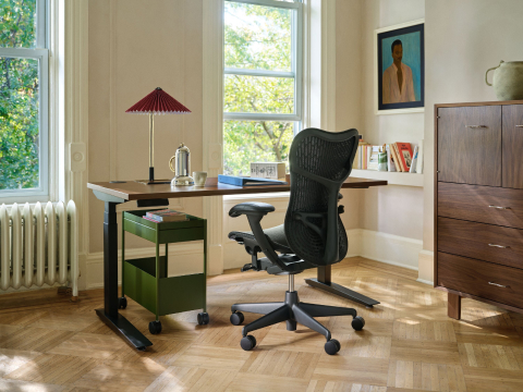 Home office workspace featuring a Herman Miller Mirra at a wooden desk by a window