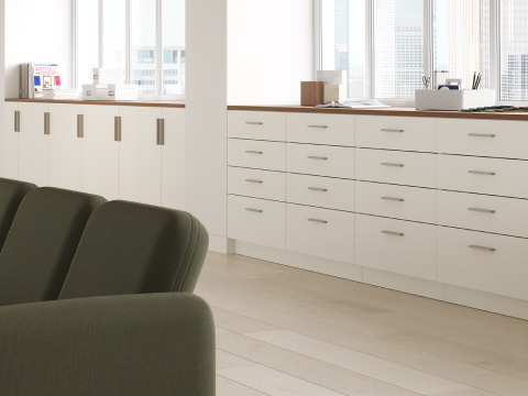 Mora System storage in a workplace setting in white finishes and walnut top.