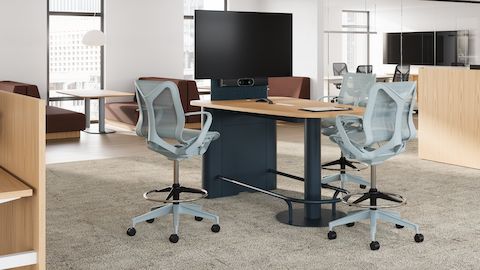 Headway Huddle Table with three glacier Cosm Stools, featuring Knoll power and table-mounted monitor in a semi-enclosed office space.