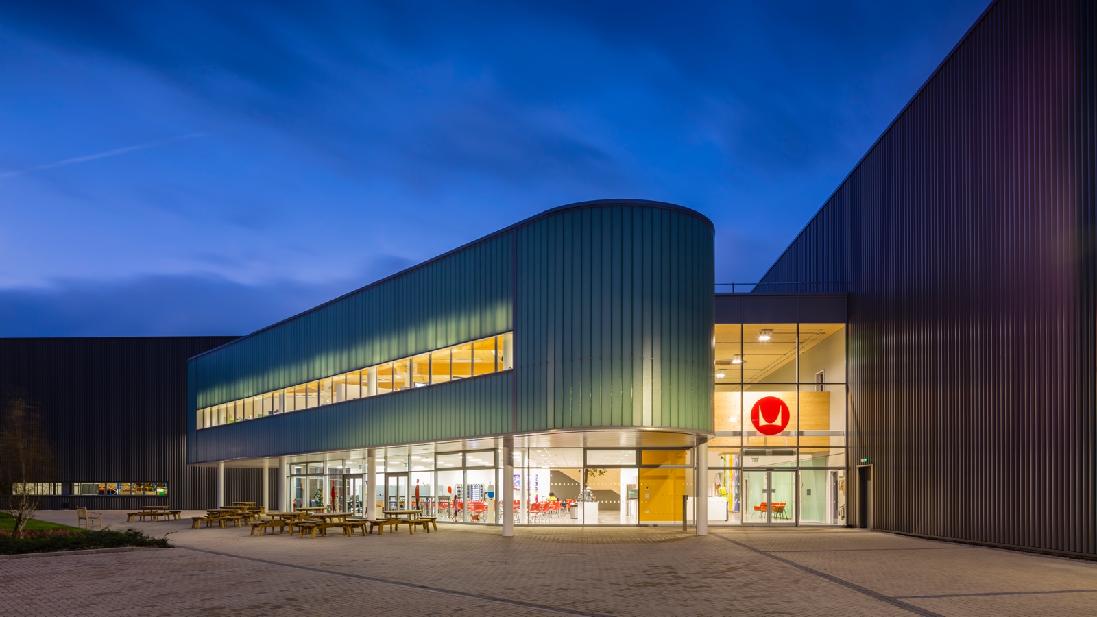 A night photo of the exterior of a Herman Miller manufacturing facility in the UK.