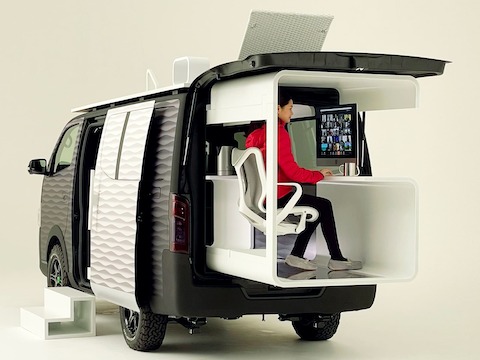 2021 日産 NV350 オフィスポッドコンセプトに設置されたコズムチェアに座る女性