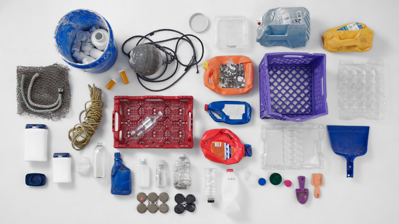 Ein Arrangement mehrfarbiger, einzeln ausgelegter Teile Ocean Bound Plastic auf einem weißen Hintergrund. Ein Arrangement mehrfarbiger, einzeln ausgelegter Teile Ocean Bound Plastic auf einem weißen Hintergrund.
