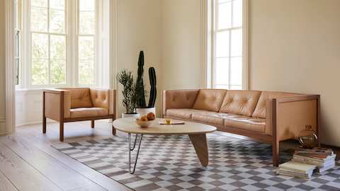 A living space featuring a Nelson Cube Sofa and Armchair, Noguchi Rudder Table and Girard Check Rug.