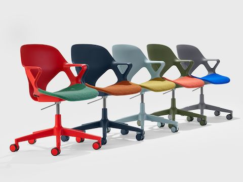 Five Zeph chairs with fixed arms in a line including a red chair with green seat pad, dark blue chair with orange seat pad, light blue chair with yellow seat pad, olive chair with light orange seat pad and a grey chair with a blue seat pad.