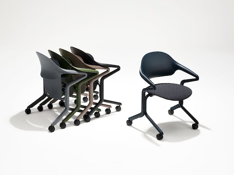 Cuatro sillas nido Fuld en varios colores y acabados anidadas en grupo junto a una única silla nido Fuld en color Nightfall con el textil 3D.