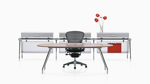 Ein schwarzer Aeron Bürostuhl ergänzt eine Arbeitsumgebung mit einem ovalen Schreibtisch und Lagerkomponenten von AbakEnvironments.