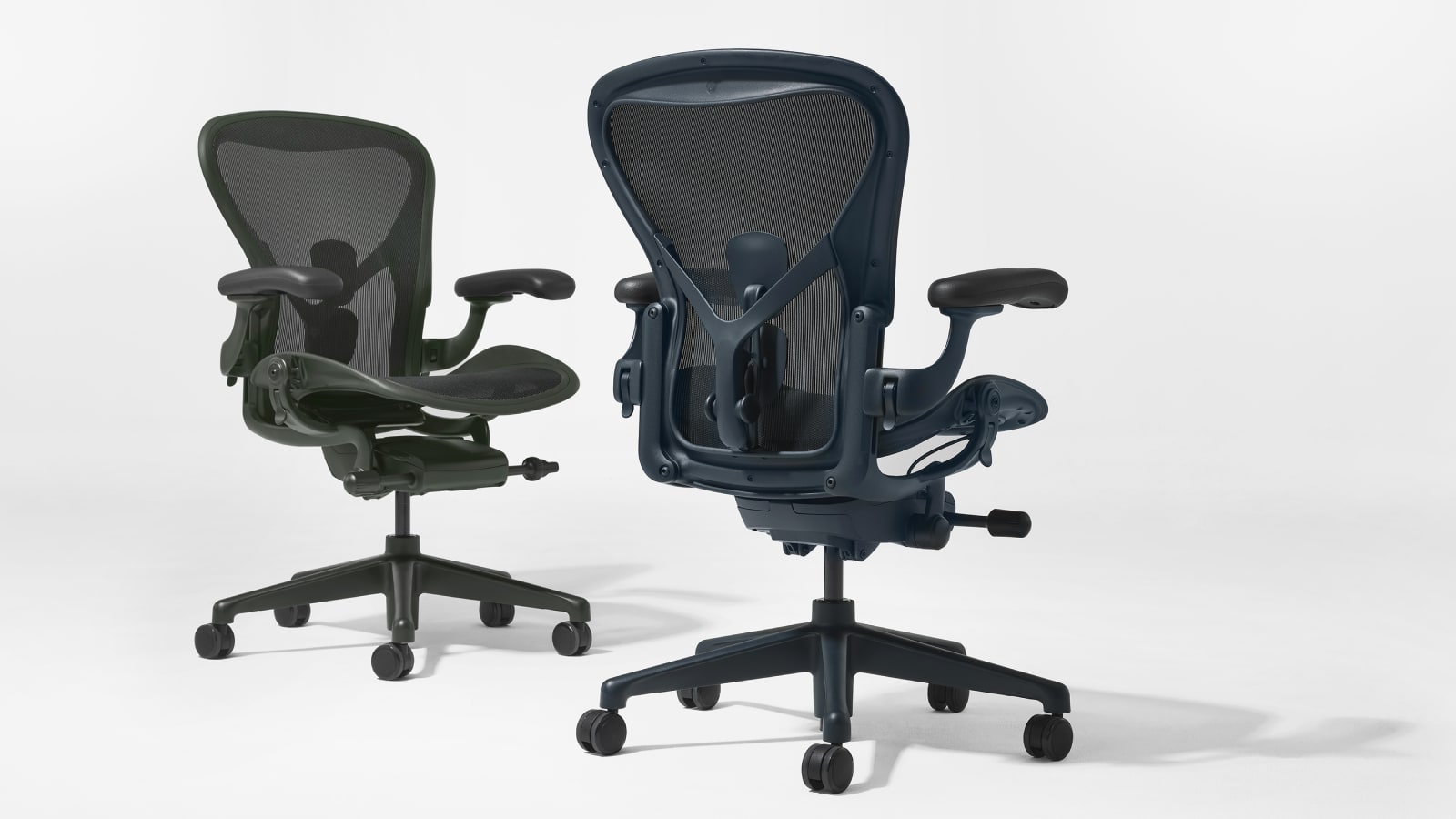 Sillas Aeron de color verde oscuro y azul oscuro, colocadas una al lado de la otra.