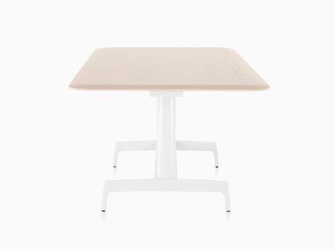 Ein rechteckiger AGL Tisch mit einer hellen Furnierplatte und einer weißen Aluminiumbasis, vom schmalen Ende aus gesehen.