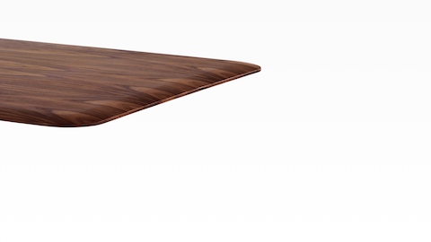 Vue partielle d'une table rectangulaire AGL avec un plateau en placage foncé.