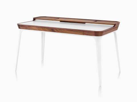 Modern Airia home office desk from Herman Miller in white with dark wood trim and white legs in three quarter view.