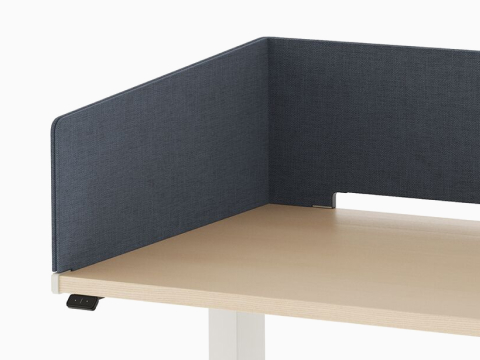 Open, navy metal storage attached to laminate surface of desk with navy fabric wrapped screen.