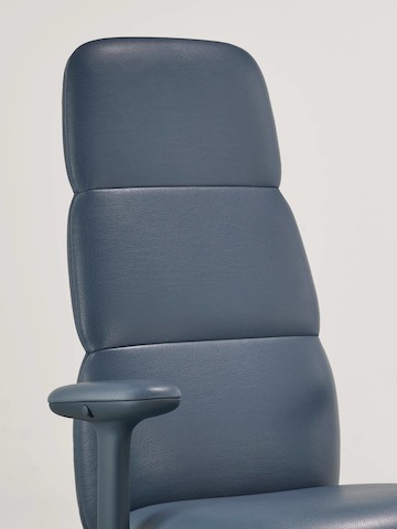 Vista detallada de una silla Asari con respaldo alto de Herman Miller en cuero azul oscuro con brazos con altura ajustable