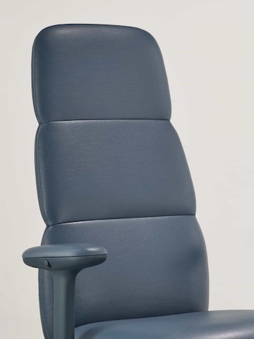 Dettaglio di una seduta Asari con schienale alto di Herman Miller, in pelle blu scuro, con braccioli regolabili in altezza