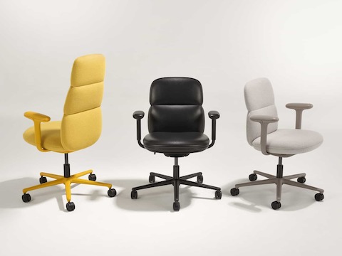 Een groep van drie Asari-stoelen van Herman Miller, allemaal met in hoogte verstelbare armleuningen. Deze groep omvat een lichtbruine stoel met middelhoge rugleuning, een gele stoel met hoge rugleuning en een zwarte leren stoel met mid-back rugleuning.