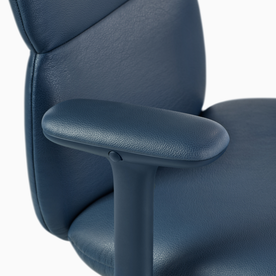 Vista em detalhes de uma cadeira Asari da Herman Miller em couro azul-escuro com braços com altura ajustável.