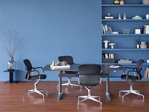 Four Keyn side chairs surround a rectangular Atlas Office Landscape table with a black top.